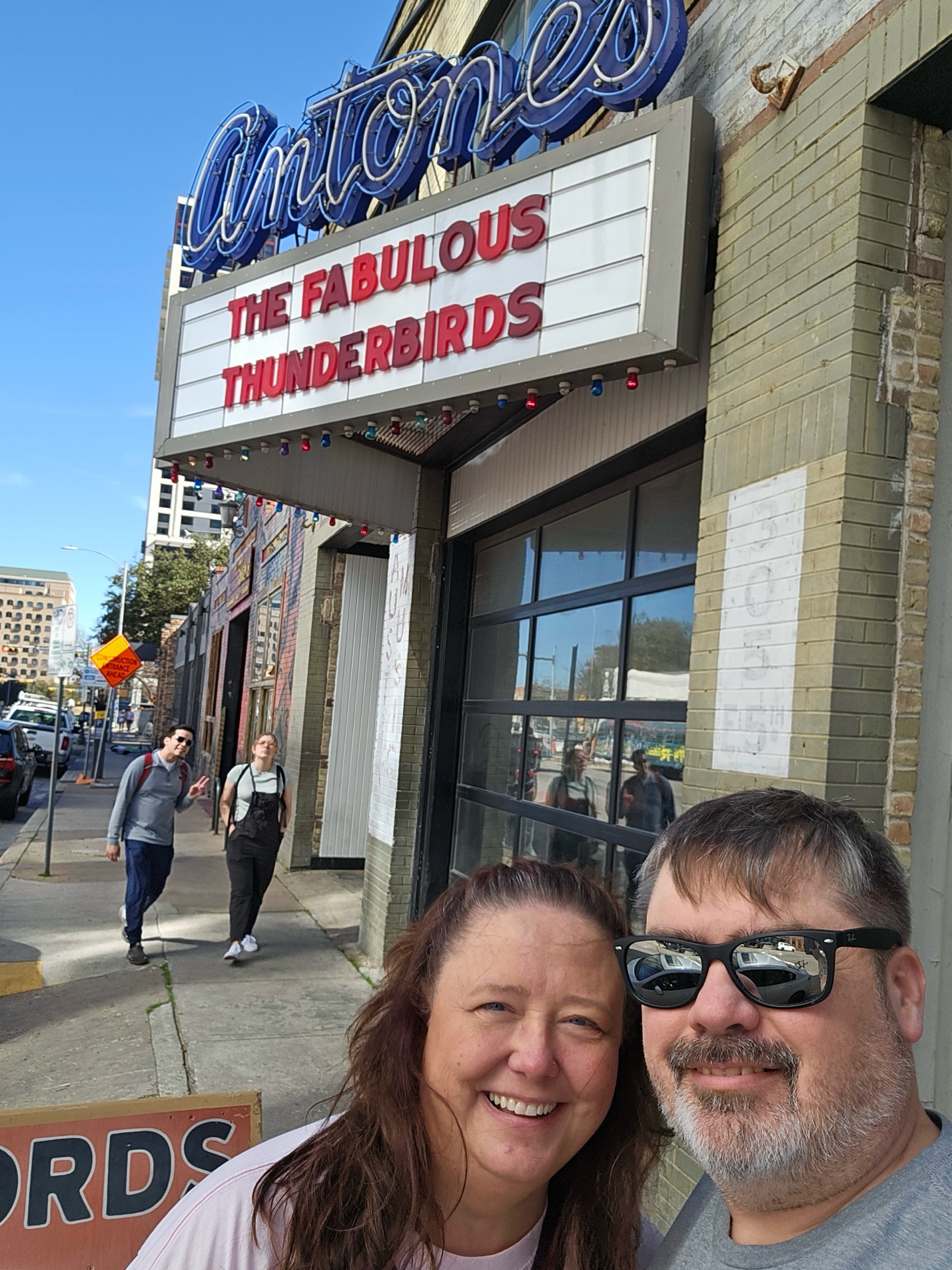 A person and person taking a selfie in front of a sign

Description automatically generated