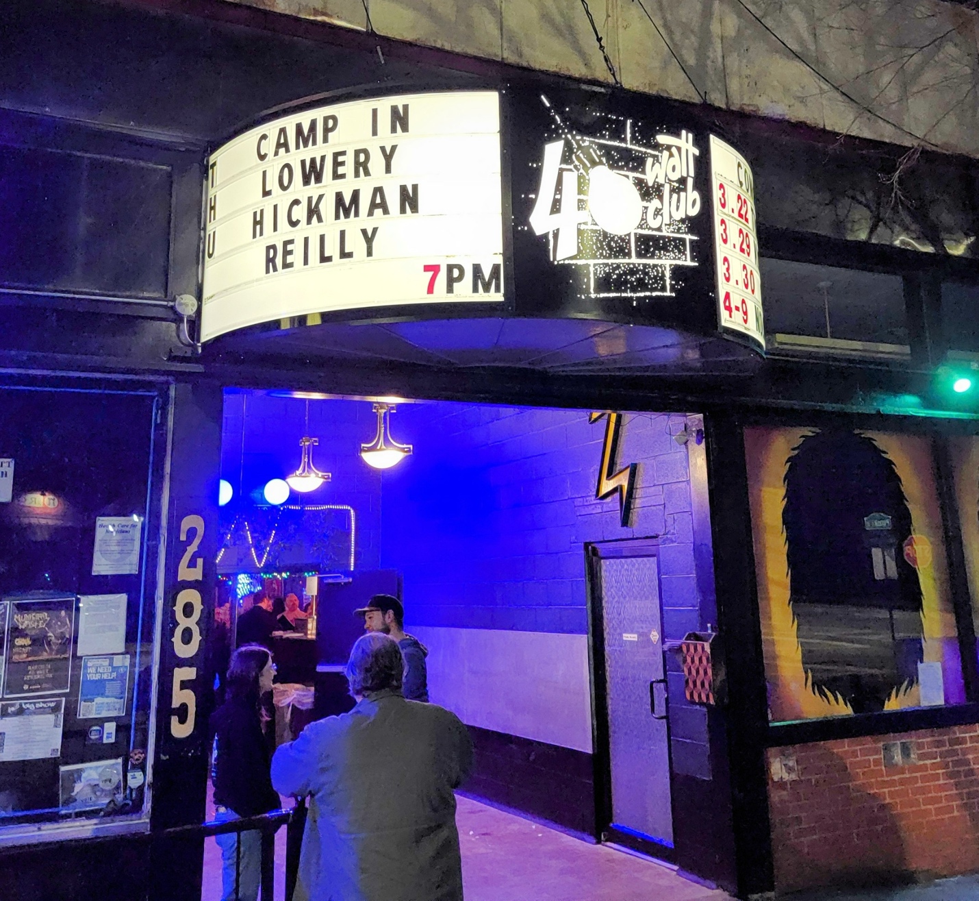 A group of people standing outside of a buildingDescription automatically generated